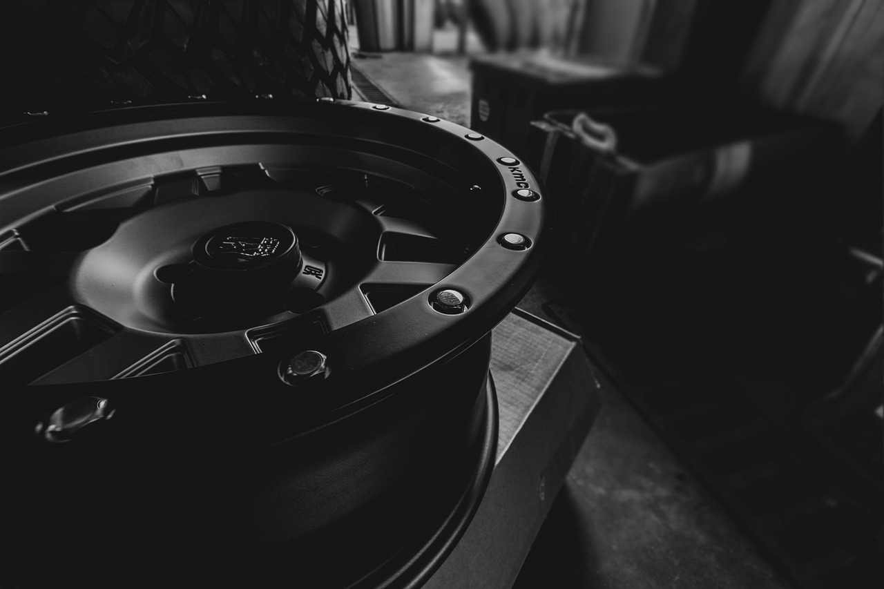 A car wheel in a dark room amidst other car parts