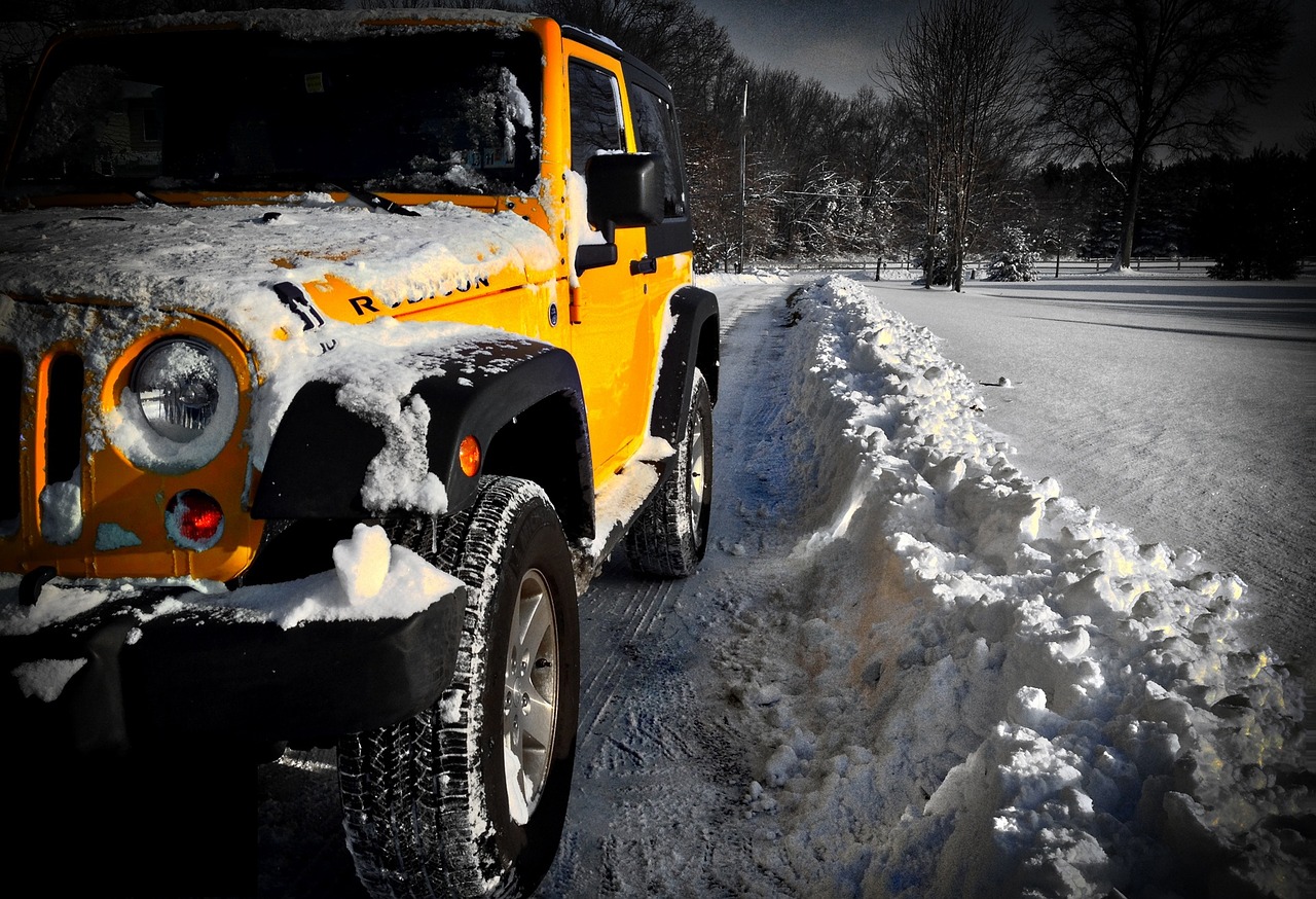 A Jeep Wrangler driving through snow