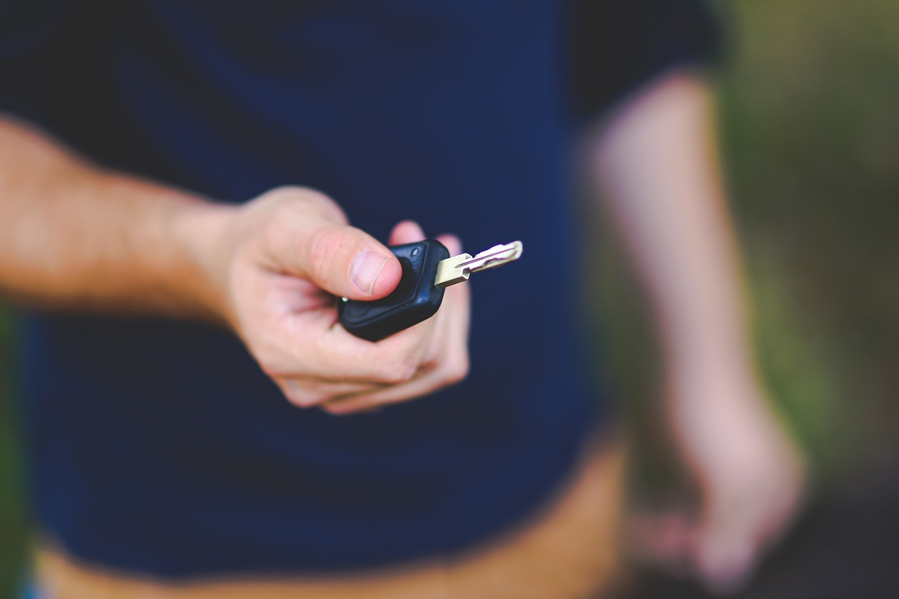 A man holding out a car key