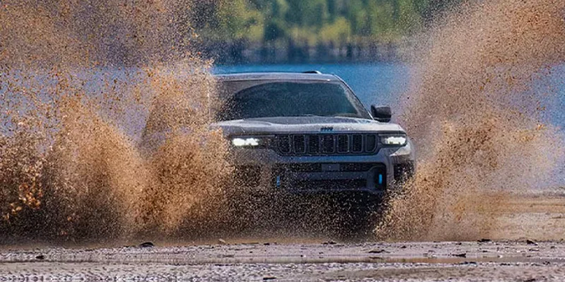 A 2025 Jeep Grand cherokee driving through mud near Highland Park, MI